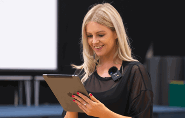 Avenue Dance Company teacher looks at tablet to process online payments for dance school