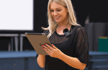 Avenue Dance Company teacher looks at tablet to process online payments for dance school