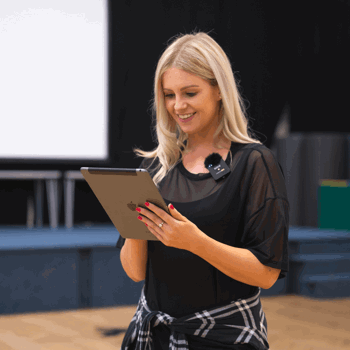 Avenue Dance Company teacher looks at tablet to process online payments for dance school
