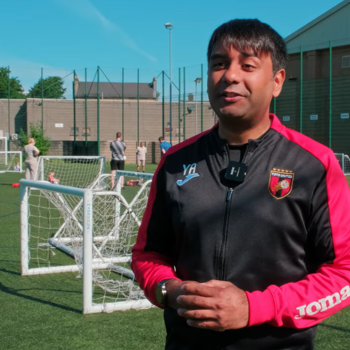 Tots United owner standing on a football pitch with pupils playing in the background